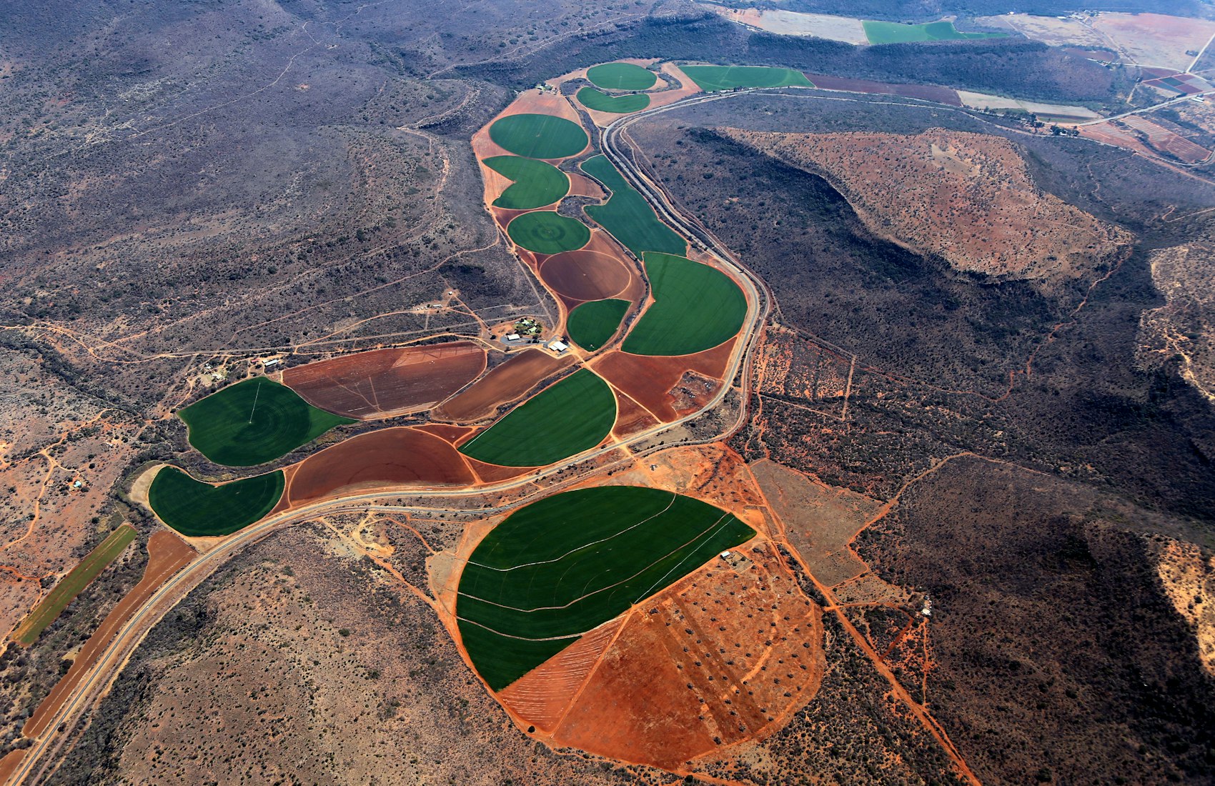 Aerial view of irrigated fields cut into dry terrain